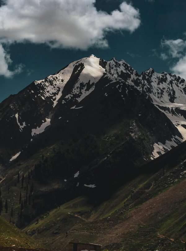 Breathtaking view of the snow-capped mountains in Murree, Pakistan under a bright cloudy sky.