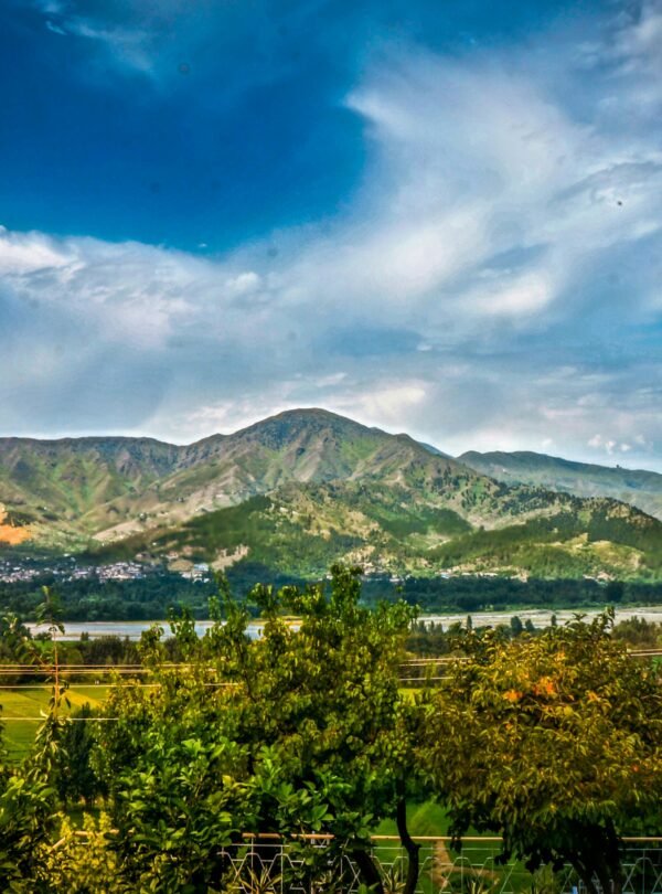 Breathtaking view of mountains and valley in Kalam, Pakistan under a vibrant sky.