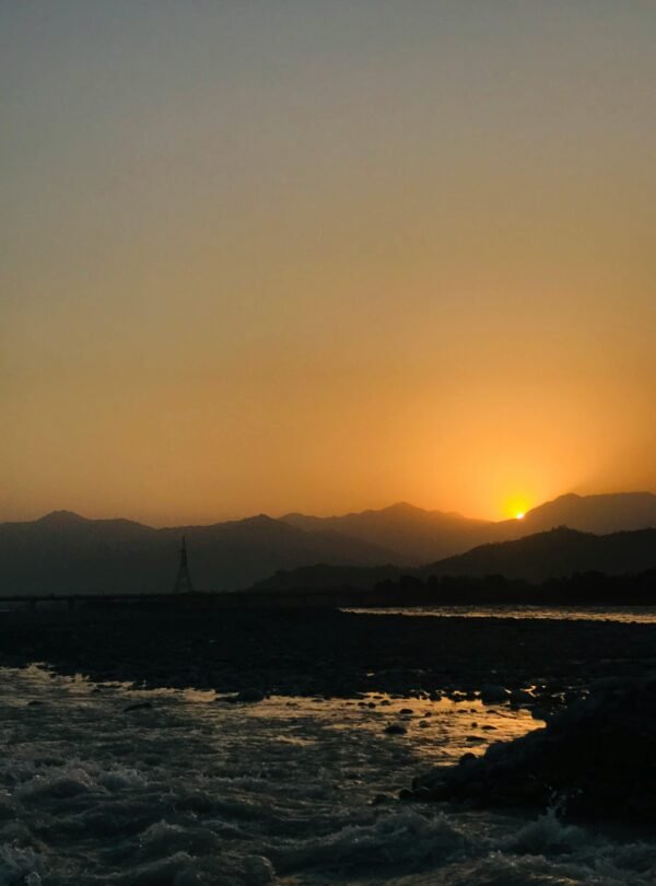 A tranquil sunset view over the river in Mingora, showcasing nature's beauty and tranquility.